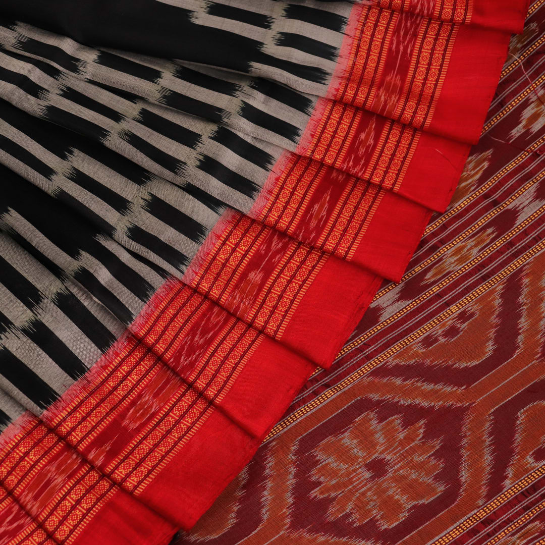 Khandua silk saree in black with red motifs, draped in a traditional style