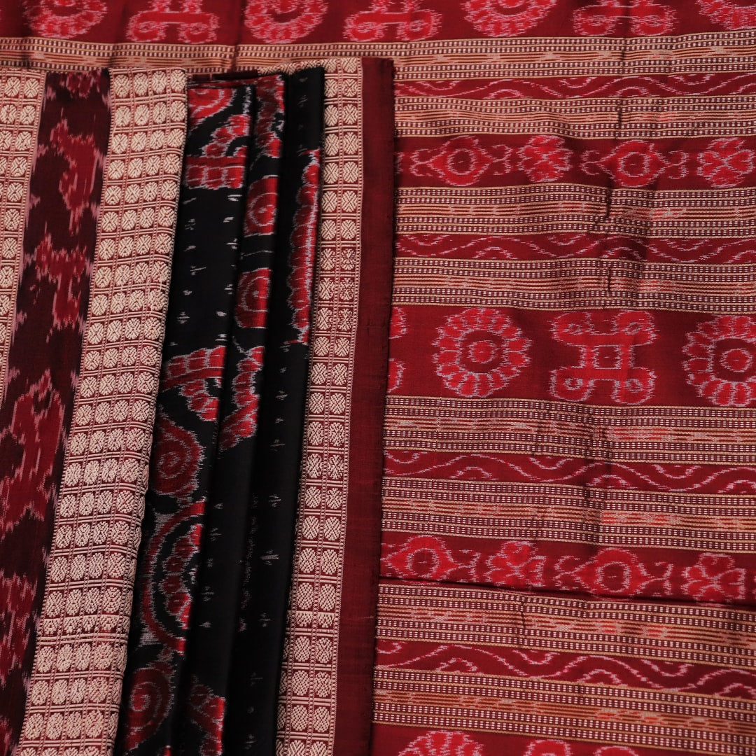 An approximately 150 cm wide handloom black silk Sambalpuri Saree with maroon motifs, captured in a close-up to depict its rich fabric texture.