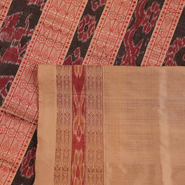 Close-up view of the richly textured silk fabric of a maroon and off-white Sambalpuri saree, featuring a delicate butta pattern.