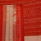 Cream and orange Sambalpuri cotton saree draped, showcasing traditional motifs and handloom texture.