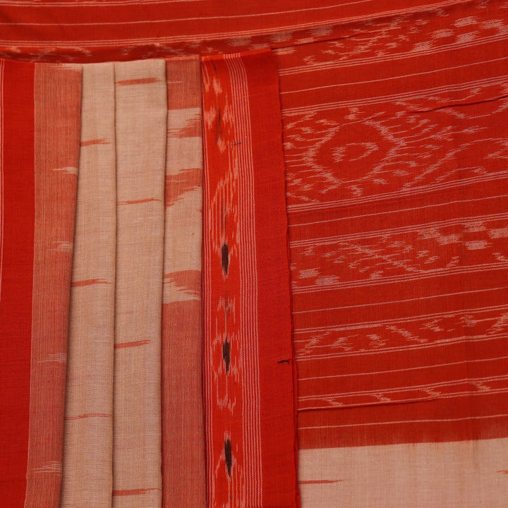 Cream and orange Sambalpuri cotton saree draped, showcasing traditional motifs and handloom texture.