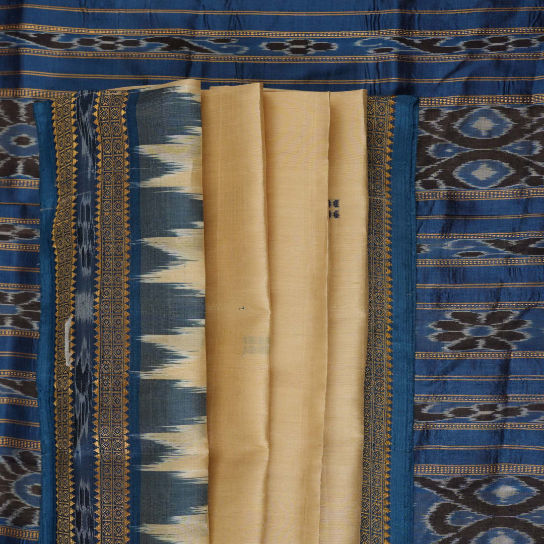 Elegant styling of cream and blue Khandua silk saree with butta pattern on model for traditional look