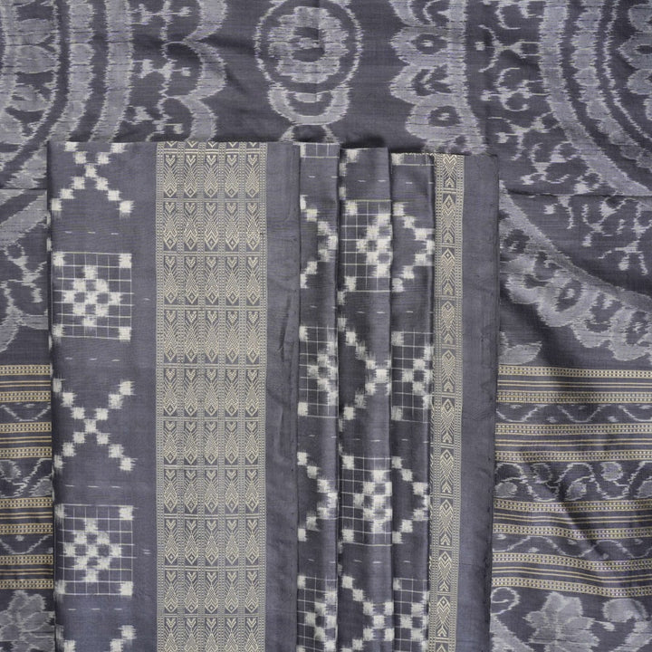 Close-up of the soft, luxurious grey Sambalpuri silk fabric texture with subtle weave details.