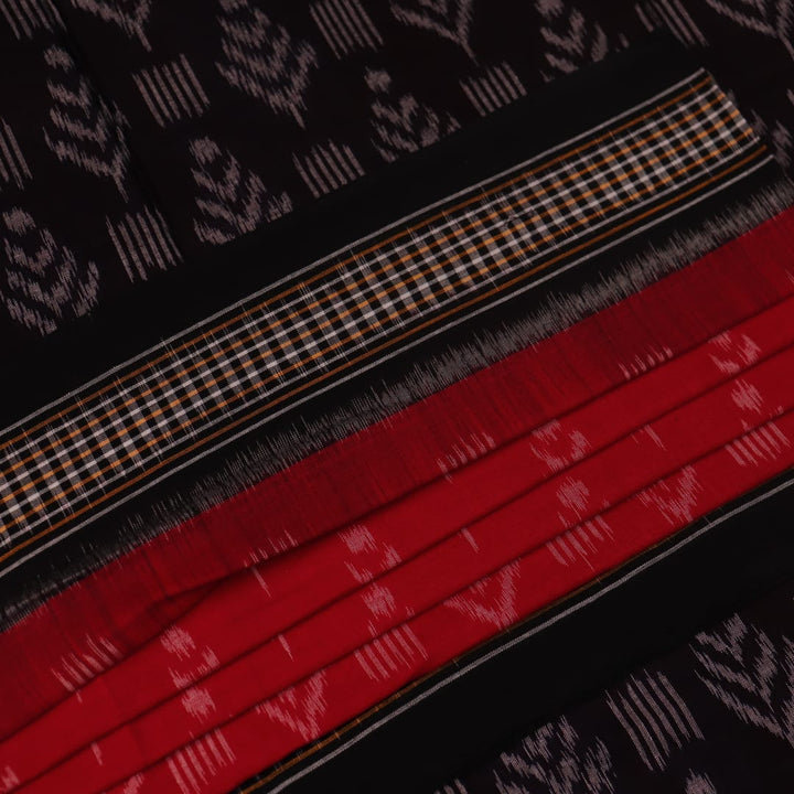 Red and black Sambalpuri cotton saree with motifs, elegantly draped to showcase its style and design.