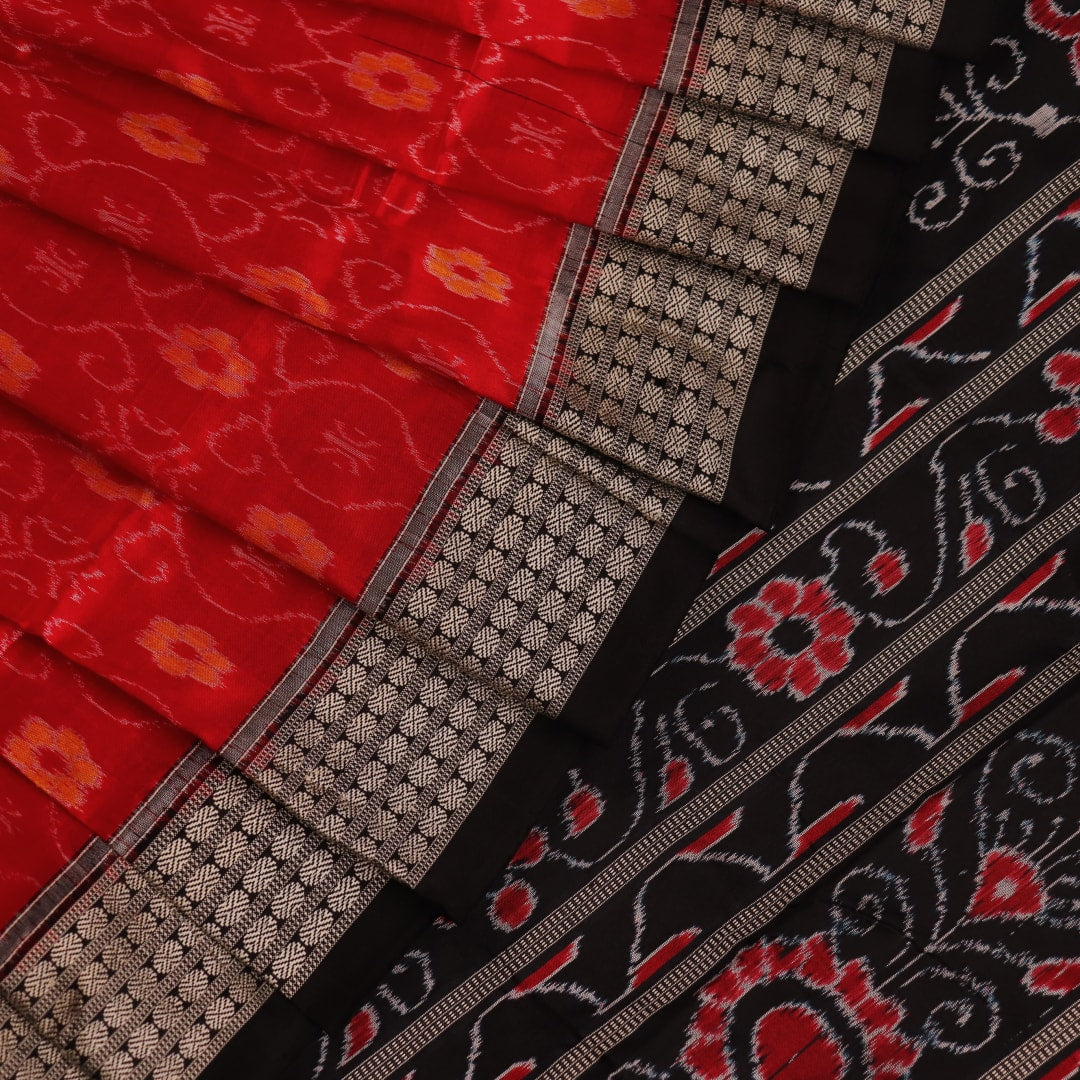 Close-up of red and black silk Sambalpuri saree fabric with intricate motifs