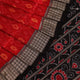 Close-up of red and black silk Sambalpuri saree fabric with intricate motifs