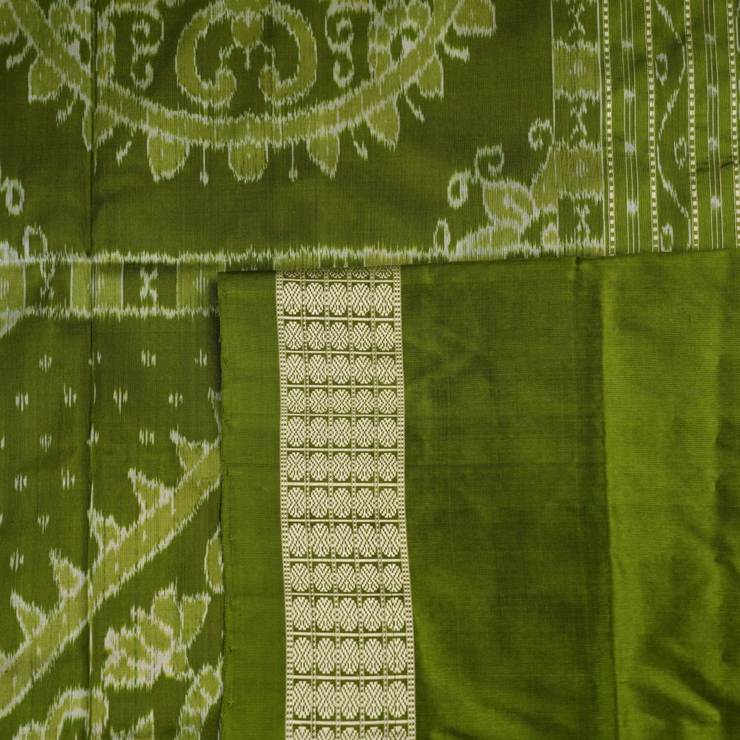 Close-up of the luxurious black and green Sambalpuri silk fabric texture and weave.