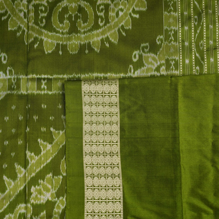 Close-up of the luxurious black and green Sambalpuri silk fabric texture and weave.