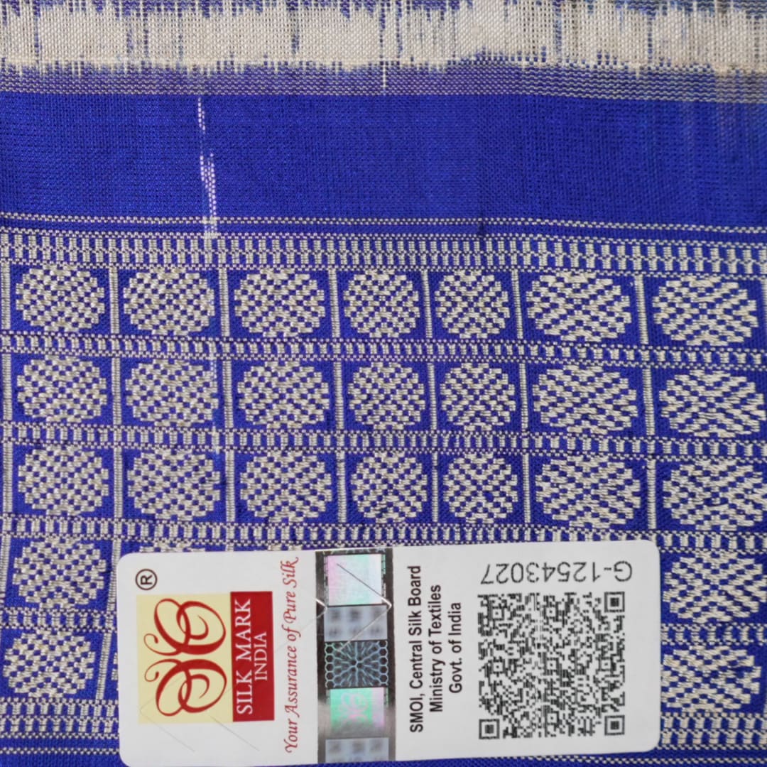Extreme close-up of the grey and blue Sambalpuri silk saree fabric, revealing its rich texture and intricate weave.
