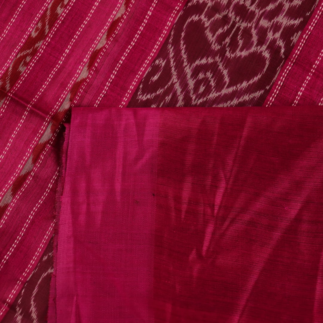 Close-up view of the luxurious texture of a plain green Tussar silk saree with a magenta border