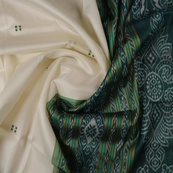 Model wearing a white Khandua silk saree with green butta and border, showcasing a graceful drape.