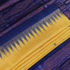 Textured close-up of yellow Bomkai silk saree fabric with blue butta pattern.