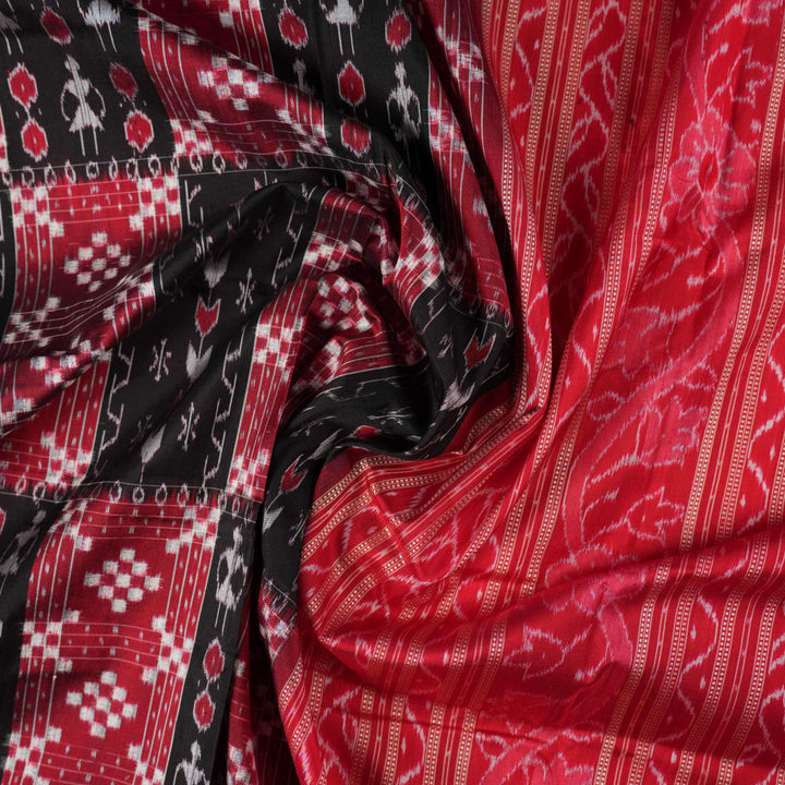 Close-up of the rich, smooth texture of the black Sambalpuri silk saree fabric.