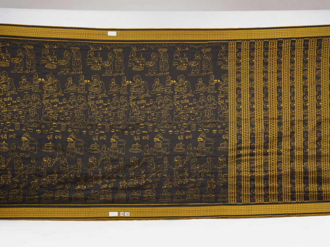 Close-up of the black Sambalpuri silk saree fabric, revealing its rich texture and the intricate weave of the motifs.