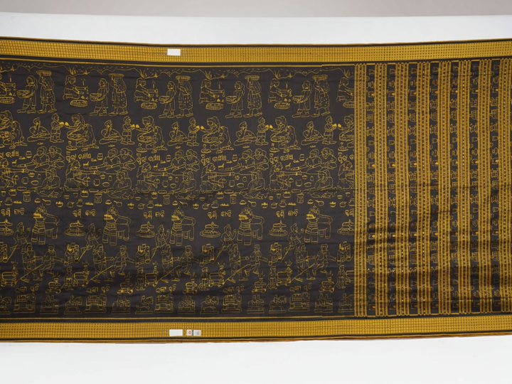 Close-up of the black Sambalpuri silk saree fabric, revealing its rich texture and the intricate weave of the motifs.