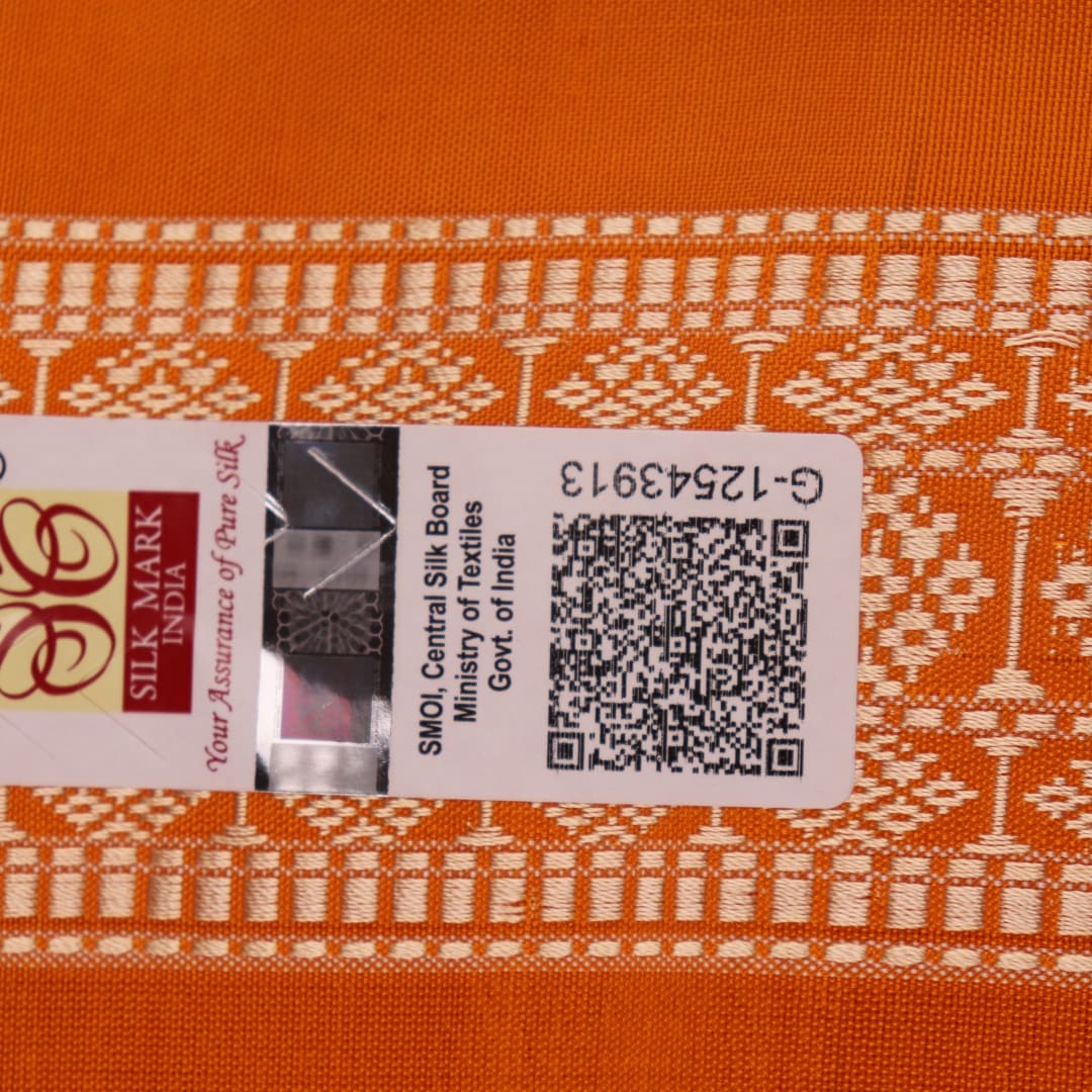 Close-up of Bomkai silk saree fabric texture in white with yellow butta pattern.