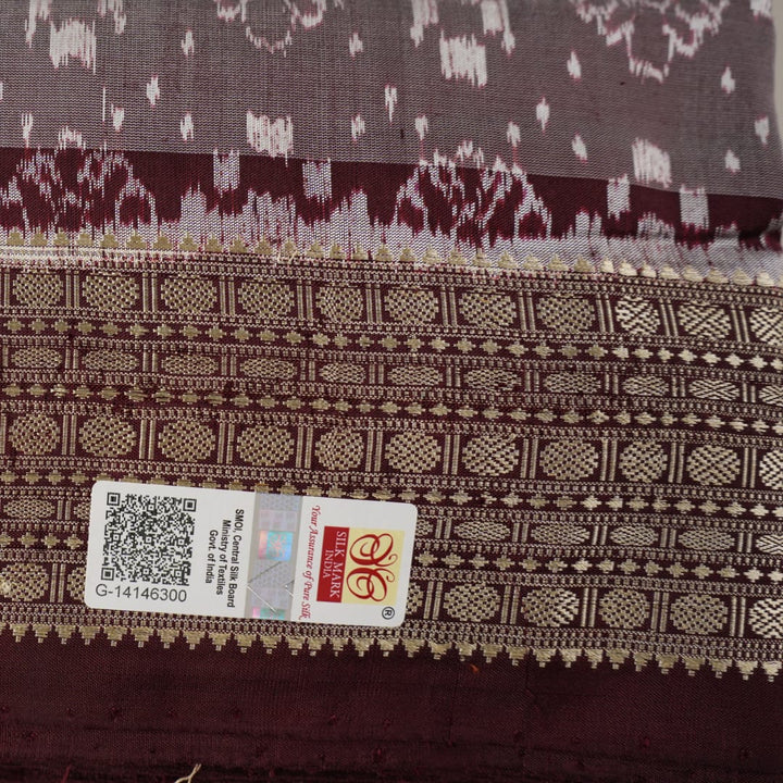 Close-up of the rich multi-color and maroon Sambalpuri silk fabric, highlighting its exquisite handloom weave texture.