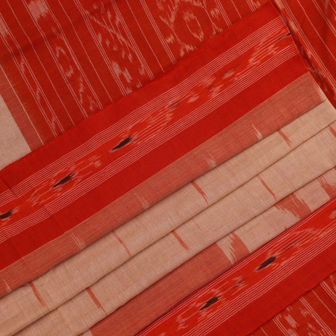 Cream and orange Sambalpuri cotton saree draped, showcasing traditional motifs and handloom texture.