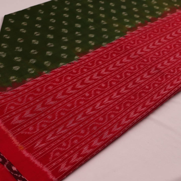 A woman wearing a green and red cotton Sambalpuri dupatta with motifs draped over her shoulder