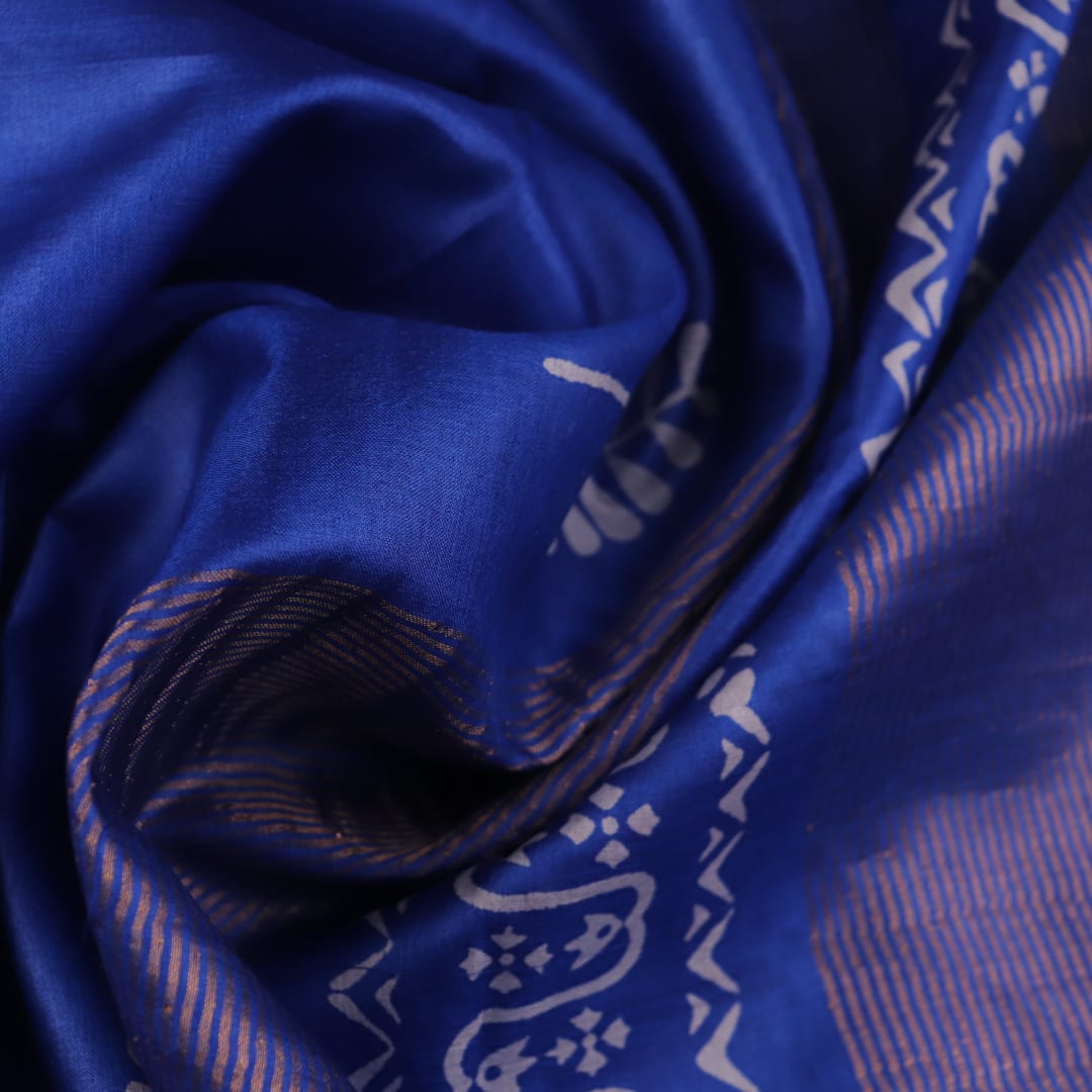 Close-up of blue printed Tussar silk handloom saree fabric texture.