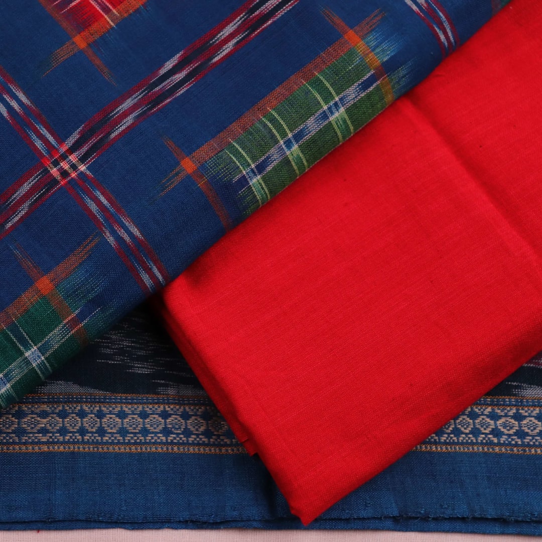 Close-up of off-white blouse piece with red motifs, paired with a Blue Sambalpuri cotton dress material.