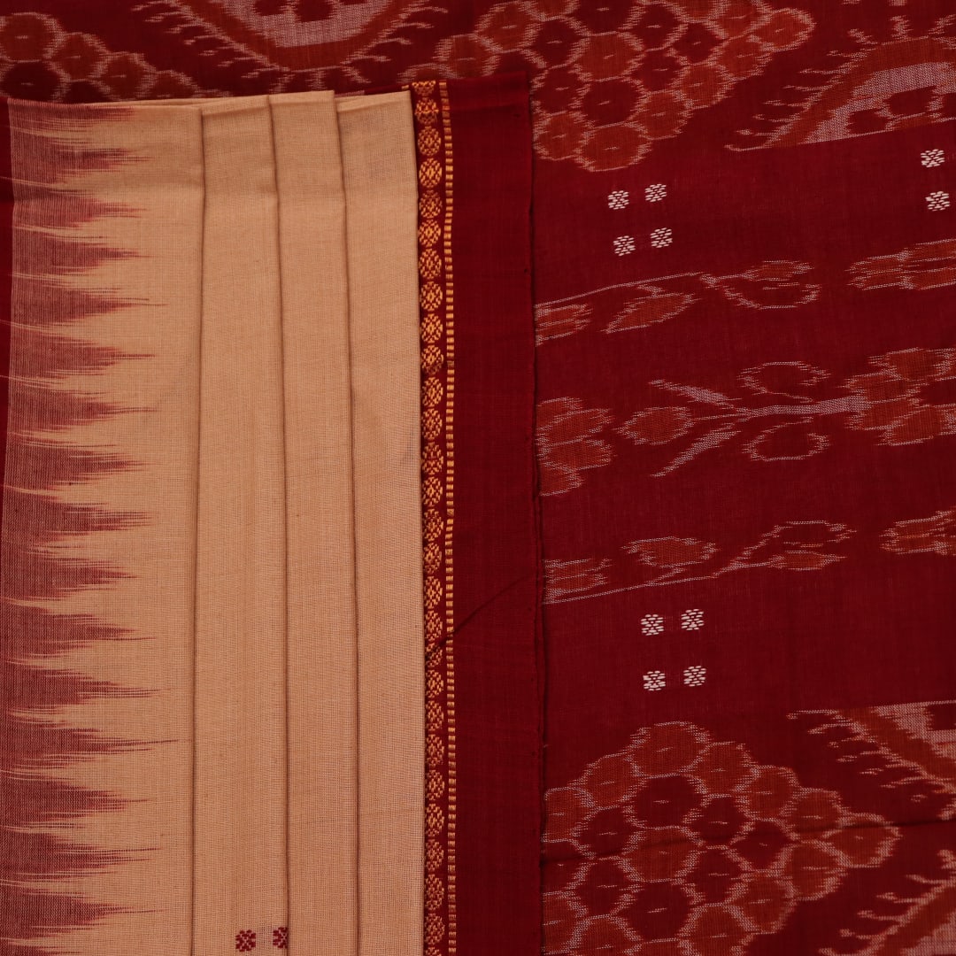 Cream-colored Sambalpuri cotton saree with maroon butta motifs, styled on a model