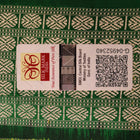 Close-up of the finely textured silk fabric in black, adorned with intricate Sambalpuri motifs in green