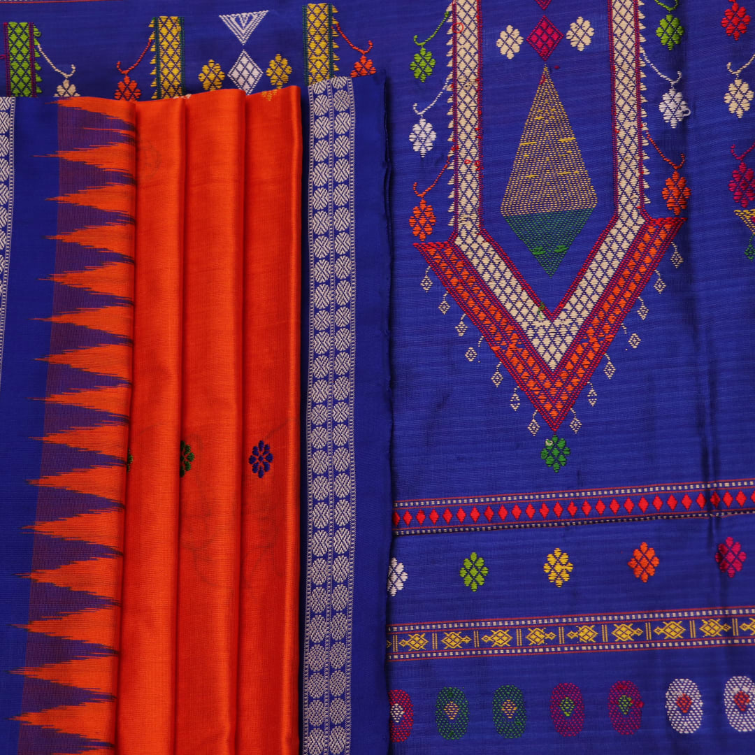 Close-up view of the vibrant orange and blue silk fabric texture with intricate butta pattern