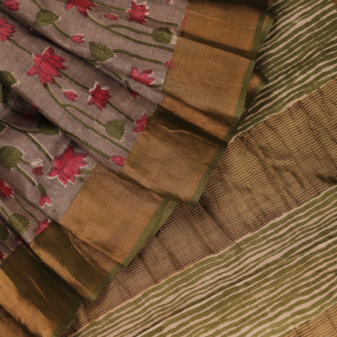 Close-up view of grey Tussar silk saree with intricate motifs on its textured fabric