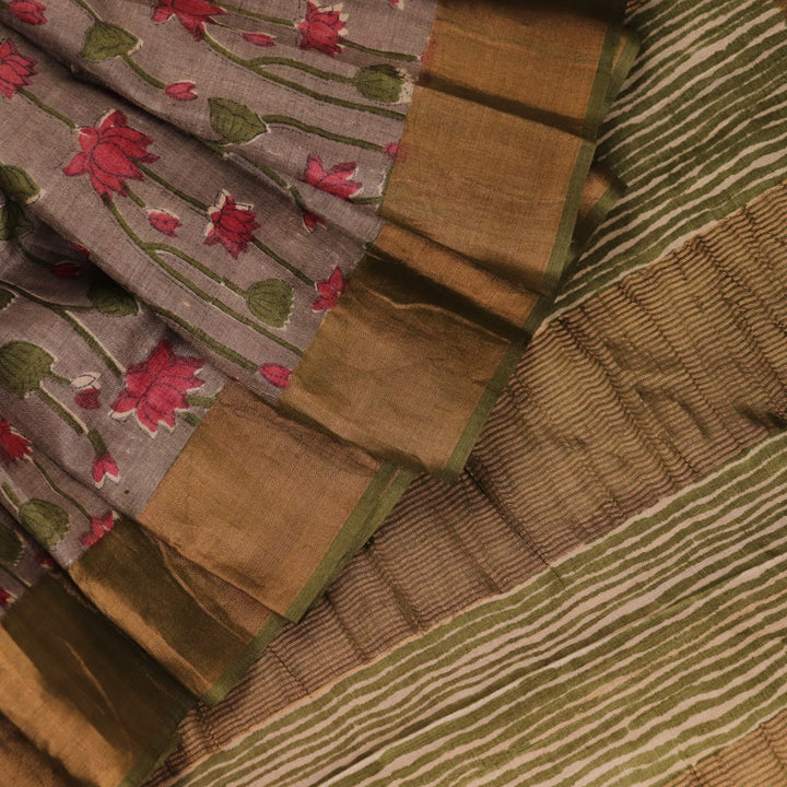 Close-up view of grey Tussar silk saree with intricate motifs on its textured fabric