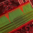 Close-up of plain green Sambalpuri silk saree fabric texture.