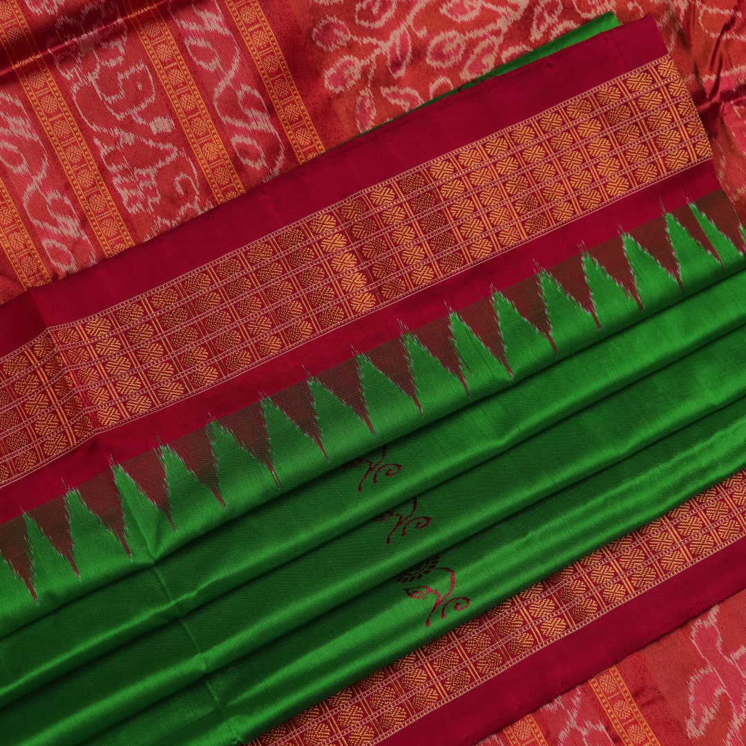 Close-up of luxurious green silk tissue saree fabric, showcasing intricate butta weaving details.