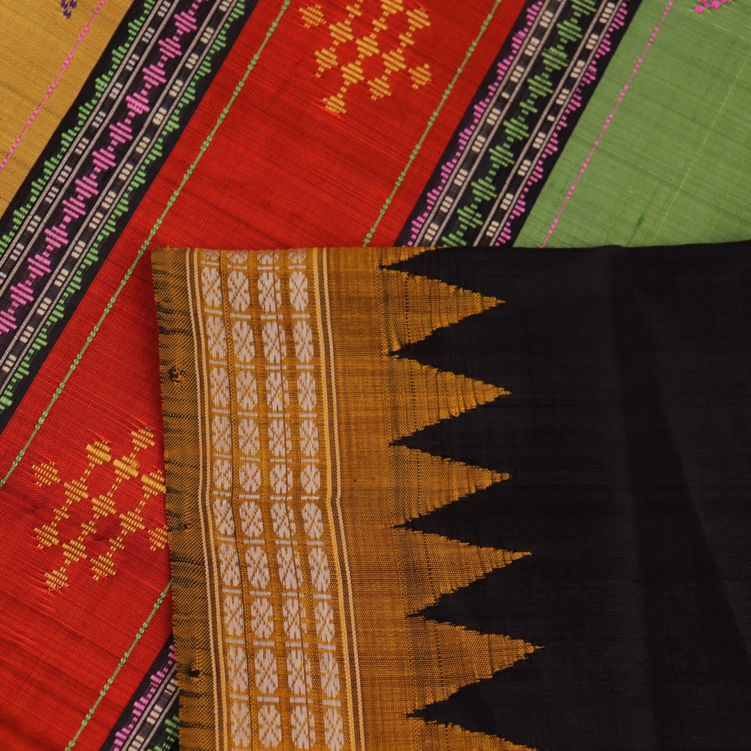 Close-up view of the golden silk fabric with black butta pattern of a Berhampuri silk saree