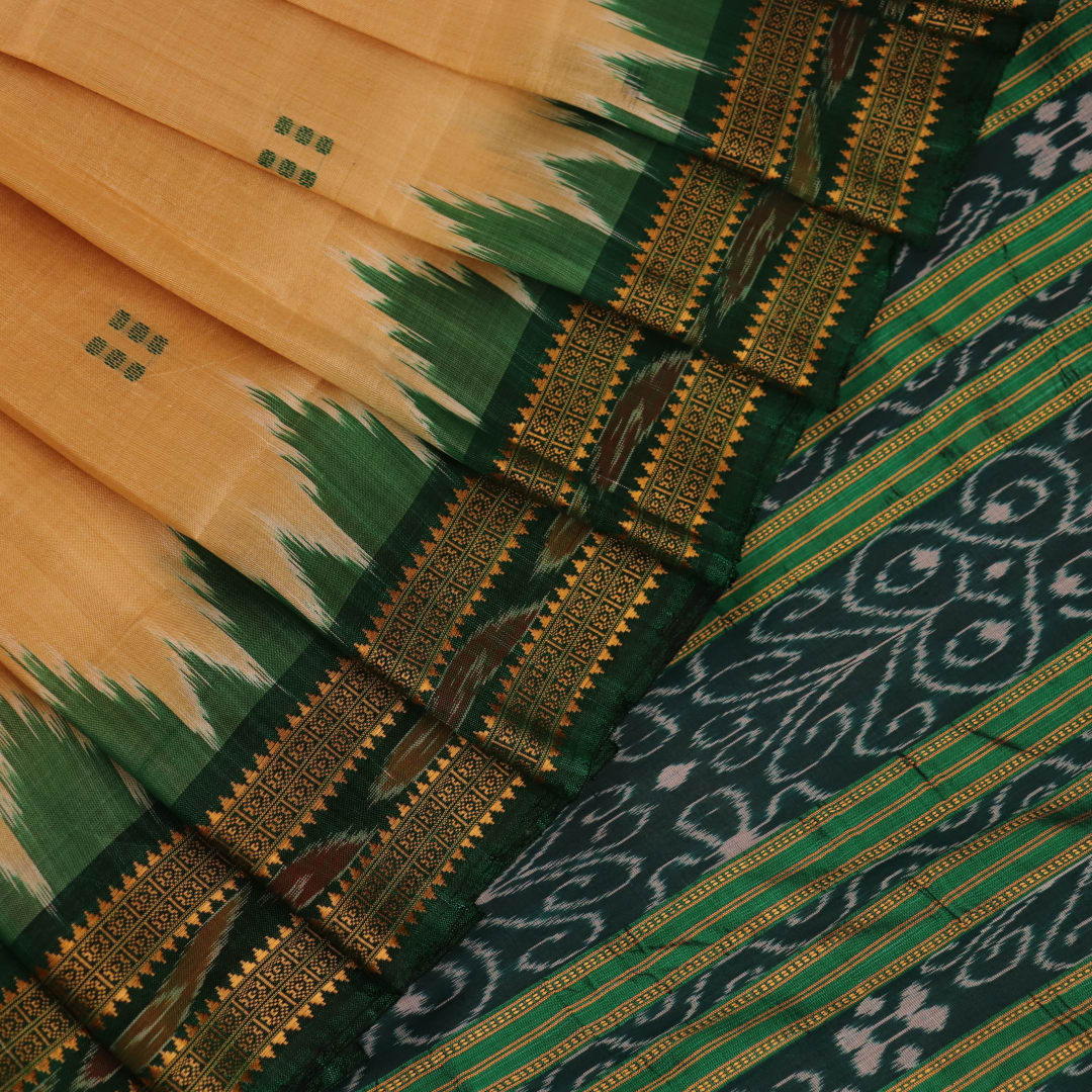 Off-white silk Khandua saree draped over a model, showcasing its intricate butta pattern and green accents.