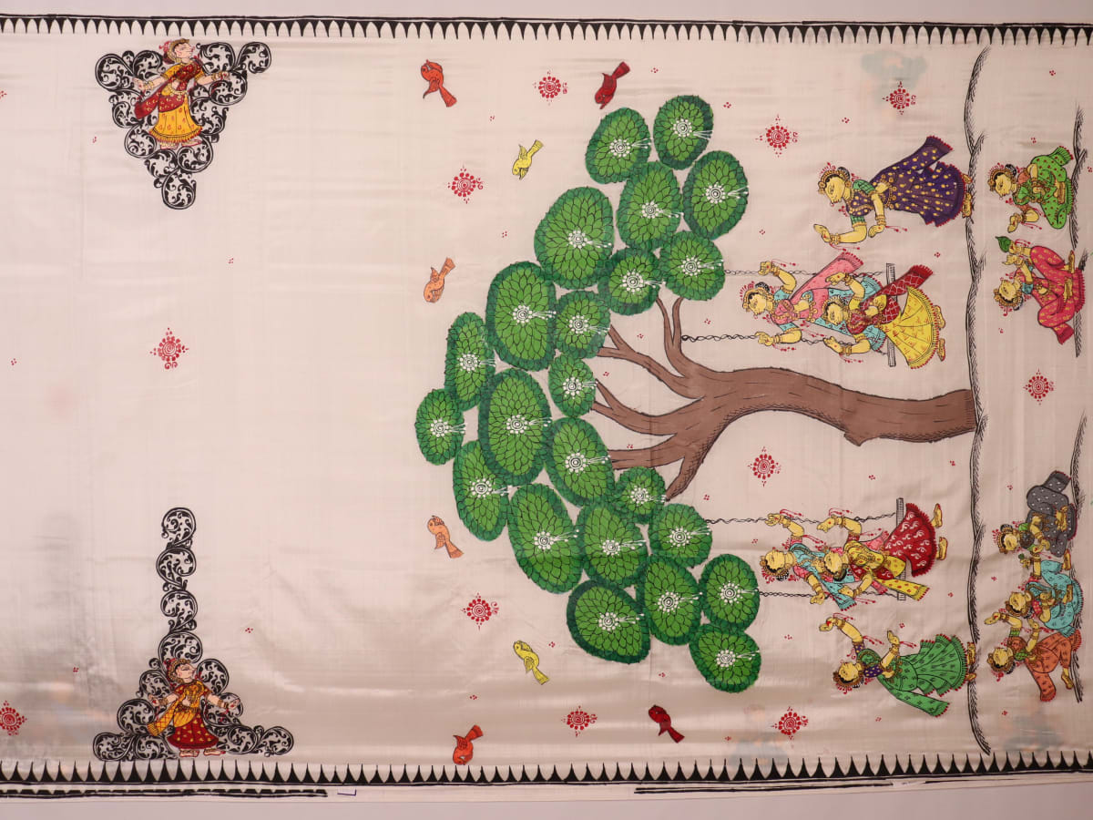 Close-up of white silk Patachitra saree fabric showing hand-painted texture and detail.