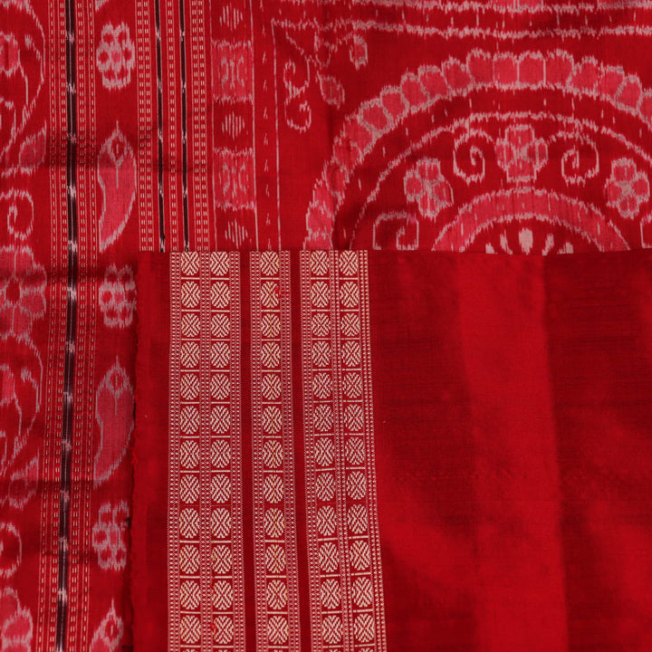 Close-up of grey Sambalpuri silk saree fabric showing intricate woven motifs and texture.