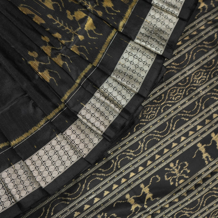 Close-up of the lustrous black Sambalpuri silk fabric, revealing its luxurious texture and fine weave.