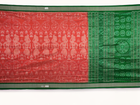 Close-up of the smooth, rich silk texture of the peach Sambalpuri saree with fine motifs.