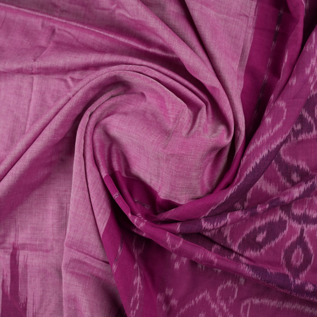 Model draped in a plain pink Sambalpuri cotton saree, styled to show the graceful fall and elegant border.