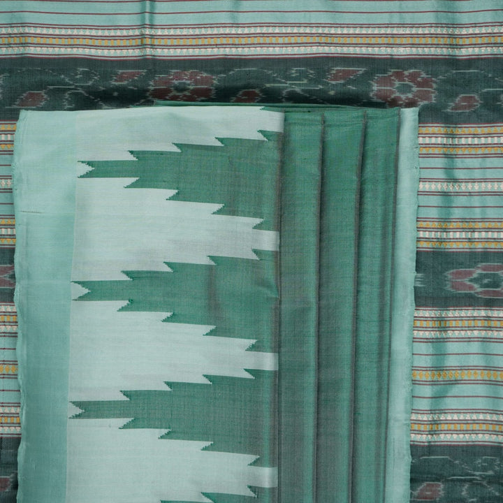 Extreme close-up of the green Sambalpuri silk fabric, revealing its luxurious texture and fine handloom weave.