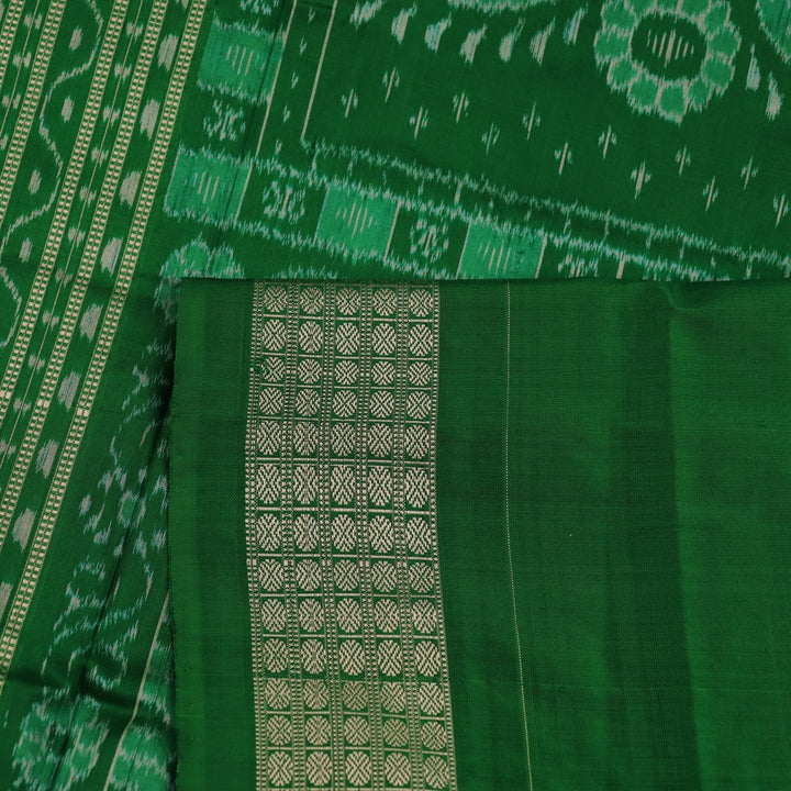 Close-up showcase of the exquisite silk texture with intricate motifs in a black and green Sambalpuri saree.