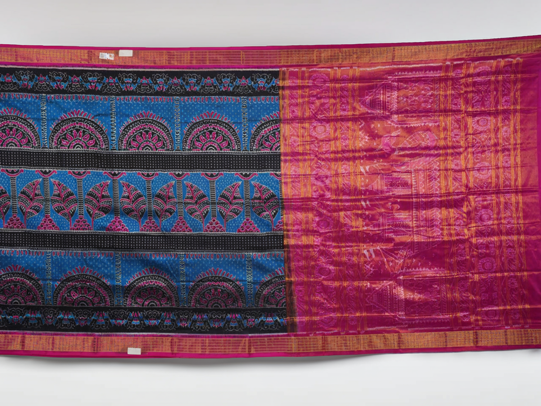 Close-up revealing the sheer tissue silk texture of the black saree, with subtle shimmering pink motifs.