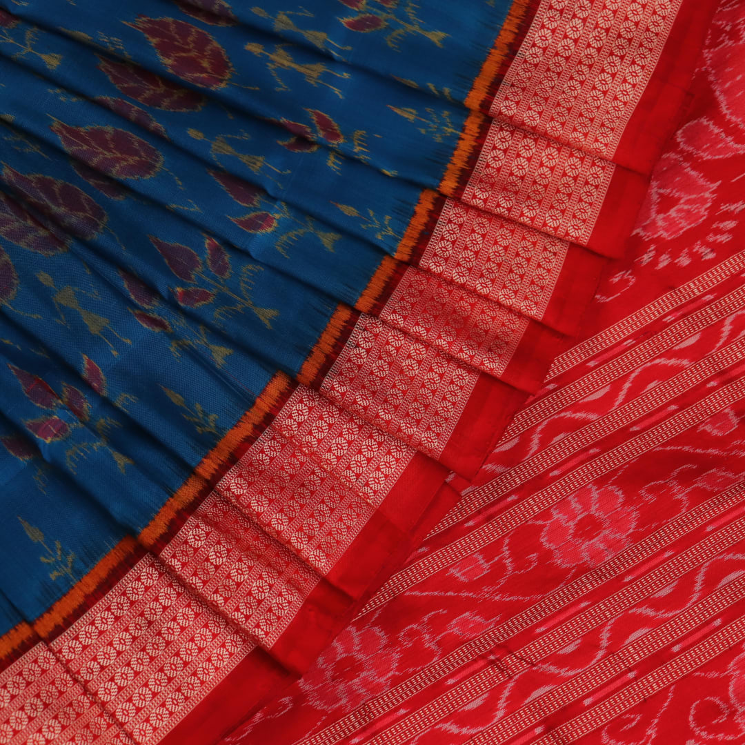 Close-up of blue and orange silk fabric texture with woven motifs