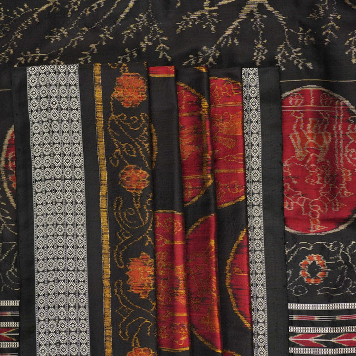 Close-up of the luxurious black Sambalpuri silk fabric, highlighting its rich texture and weave.