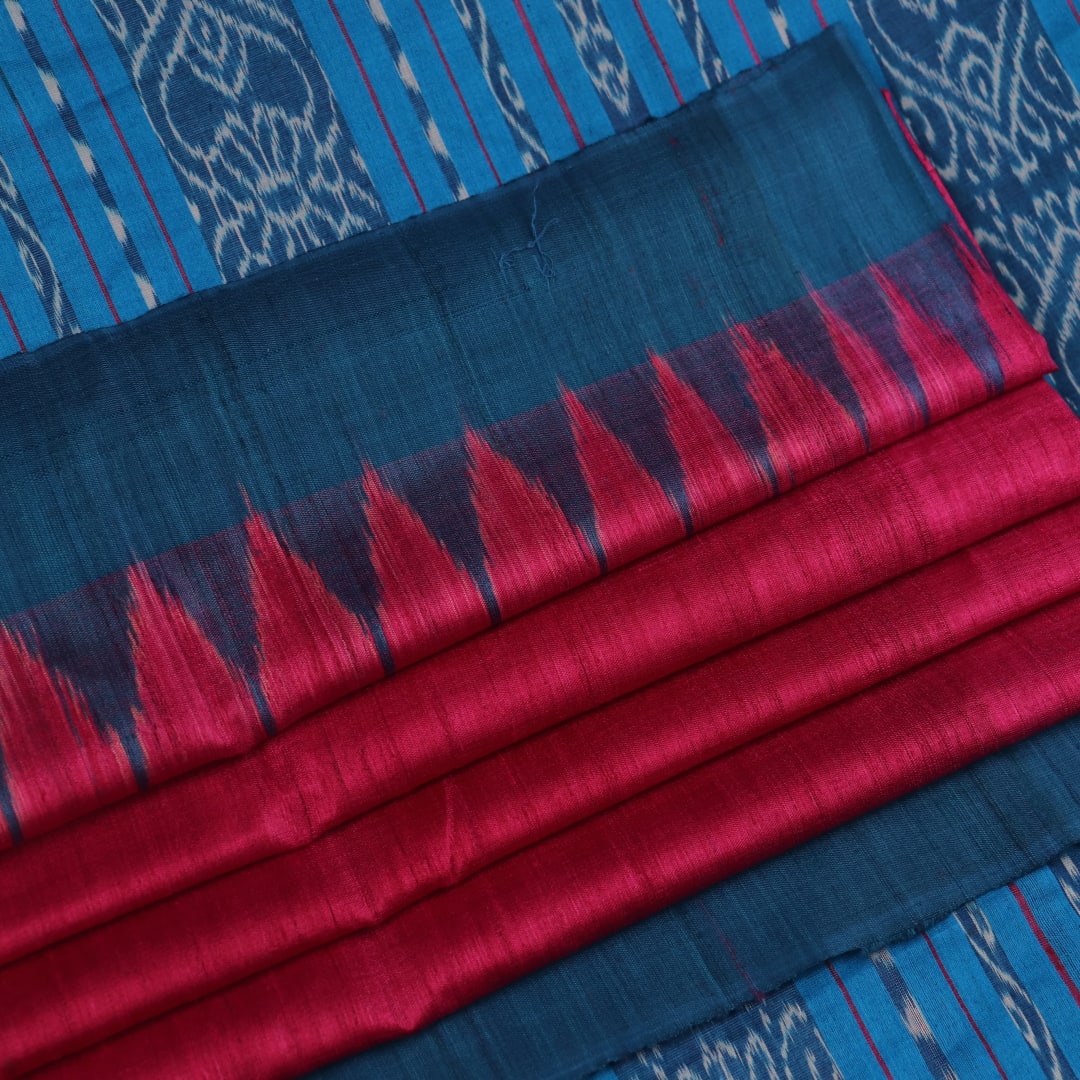 Close-up shot showcasing the textured weave of the tussar silk fabric of a plain pink and blue saree.