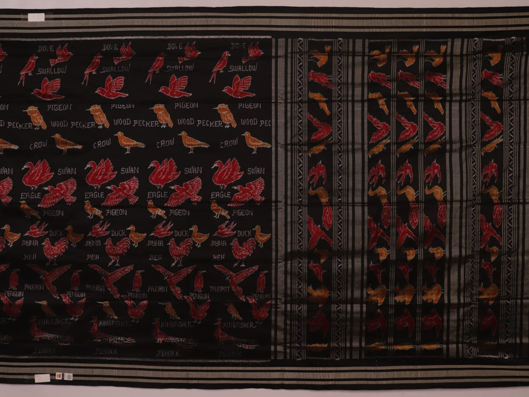 Close-up of the textured silk fabric of a black Sambalpuri saree showing intricate motifs.