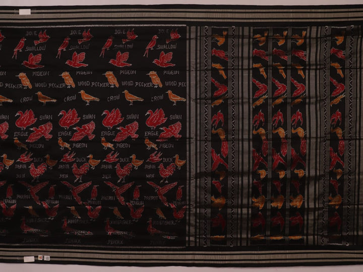 Close-up of the textured silk fabric of a black Sambalpuri saree showing intricate motifs.