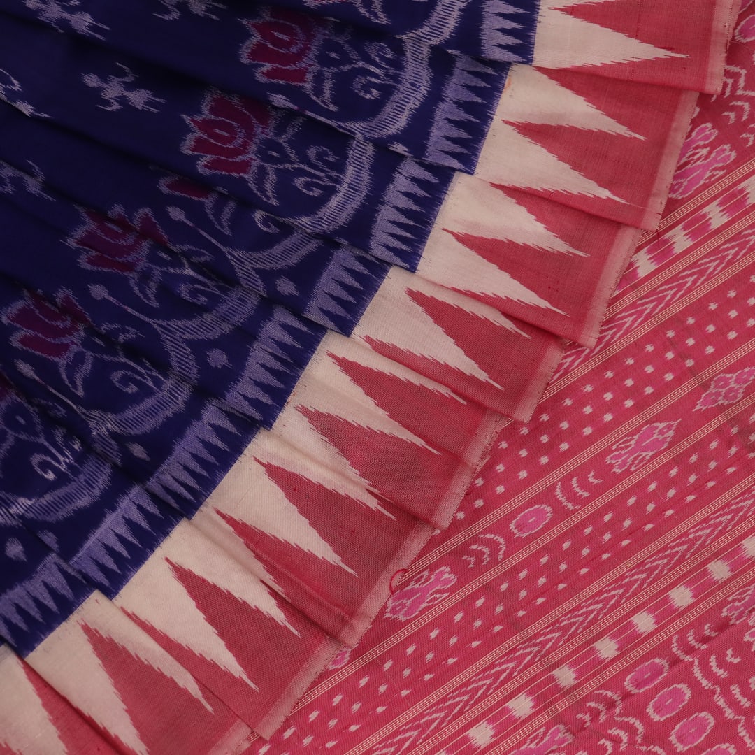 Close-up of soft, shimmering blue and peach silk fabric with intricate Sambalpuri motifs