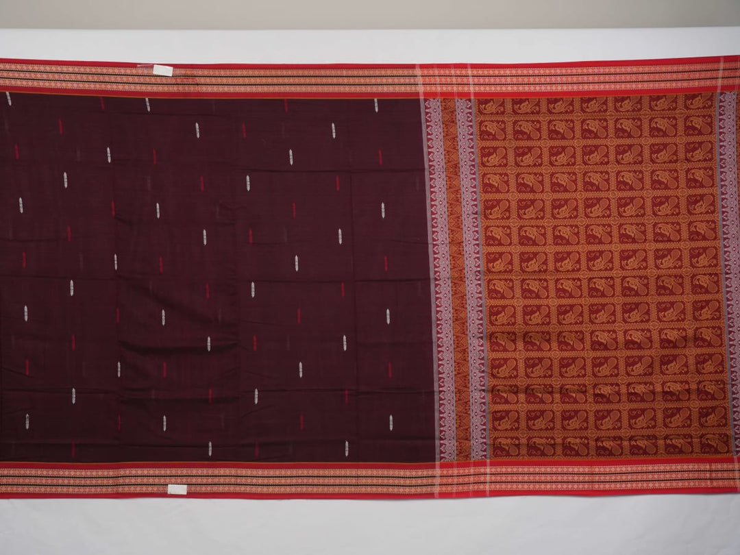 Full view of the maroon Bomkai cotton saree with red borders and small butta motifs laid out flat.