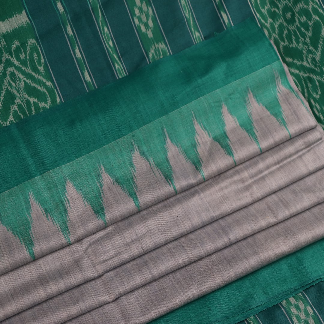 Close-up of textured grey and green Tussar silk fabric used in a plain pattern saree